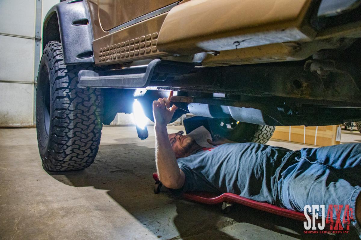 Scott under a Jeep conducting a crawl over inspection